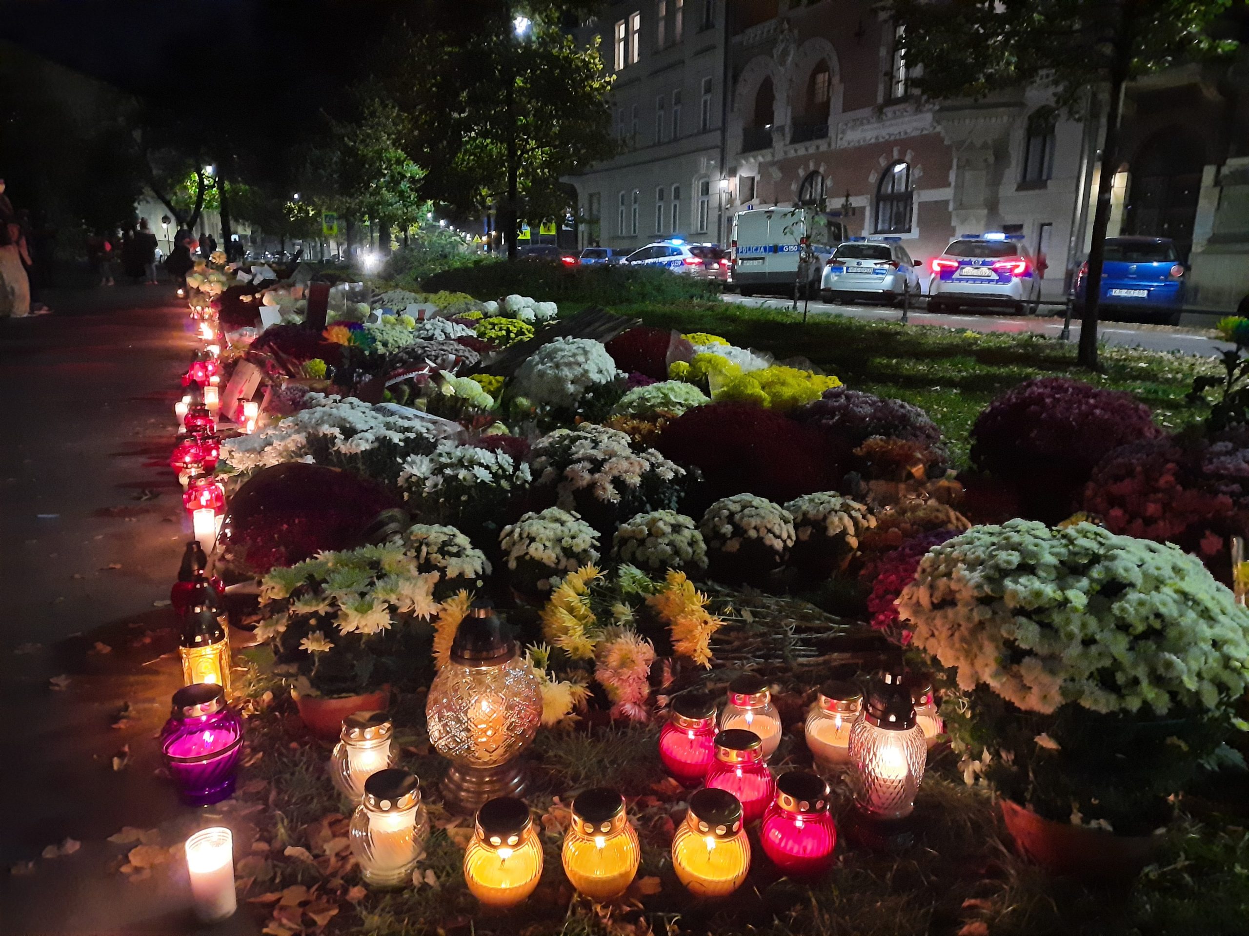 Dywan z kwiatów i zniczy pod siedzibą PiS [zdjęcia]. Marsz ulicami Krakowa [video]